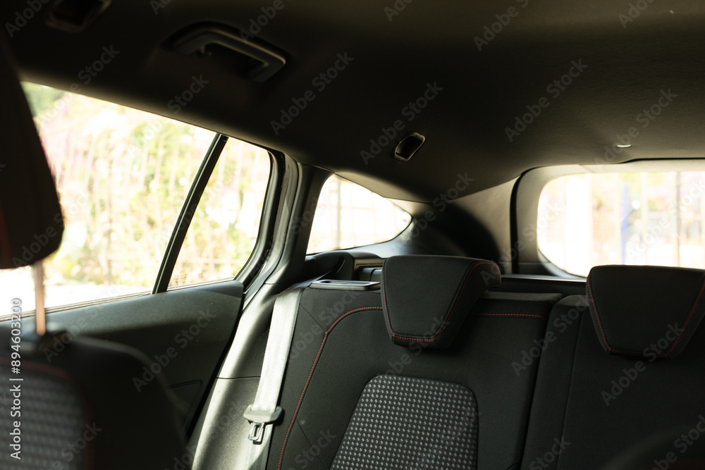 The back seats of a car with red stitching The back seats of a car with red stitching