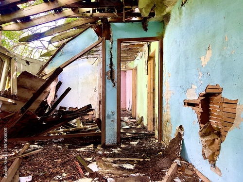 Interior of a destroyed bedroom in an abandoned house in rural North Dakota with a collapsed roof and damaged wall. photo