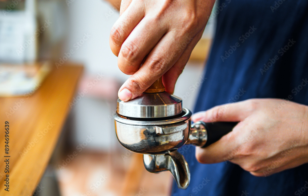 Close-up of hand Barista cafe making coffee with manual presses ground coffee using tamper at the coffee shop Close-up of hand Barista cafe making coffee with manual presses ground coffee using tamper at the coffee shop