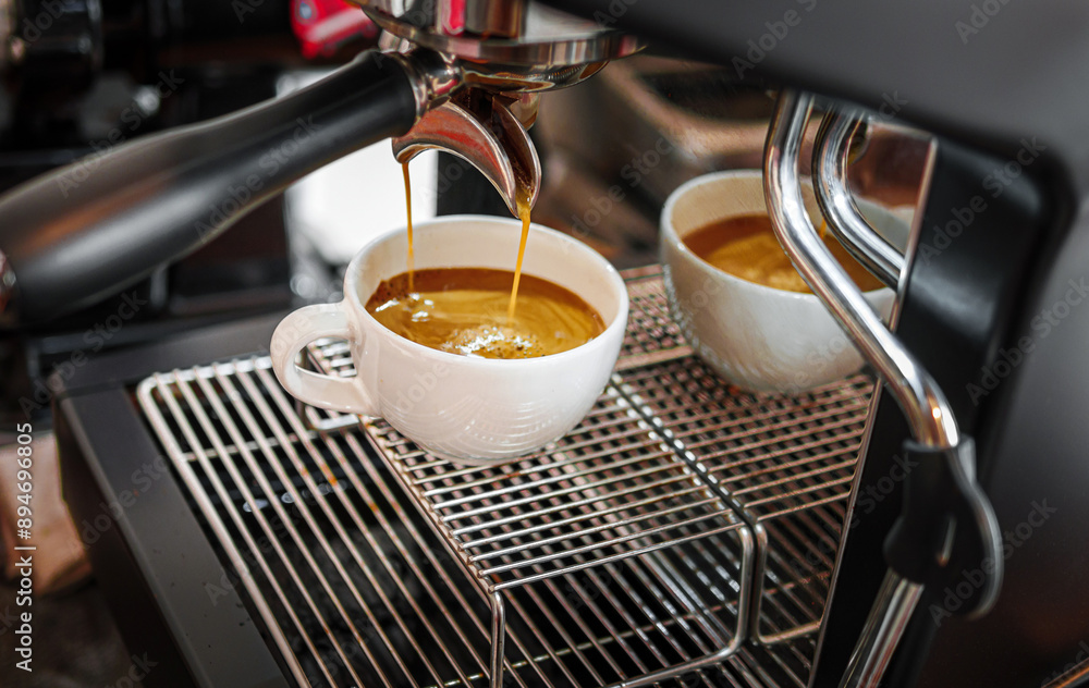 Professional espresso machine while preparing espressos coffee cup in a coffee shop. Close-up of espresso pouring from the coffee machine Professional espresso machine while preparing espressos coffee cup in a coffee shop. Close-up of espresso pouring from the coffee machine
