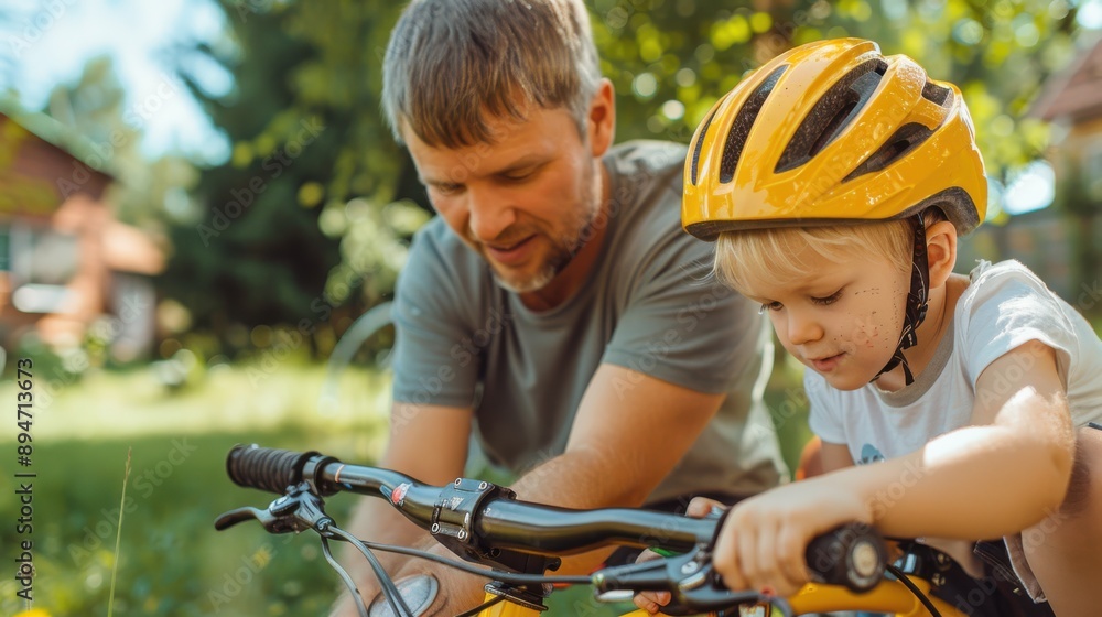 Obraz premium A father attentively teaches his young child how to ride a bike in their backyard, symbolizing parental guidance, learning new skills, and bonding through outdoor activities.