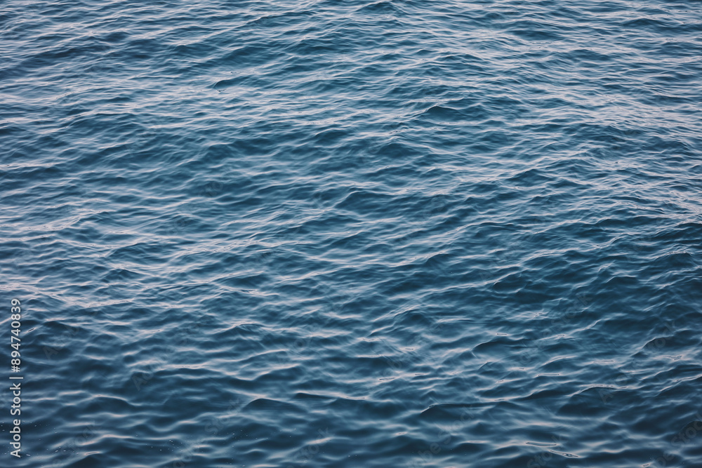 An abstract background of seawater flow under light exposure. A picture of the sea with calm waves. An abstract background of seawater flow under light exposure. A picture of the sea with calm waves.