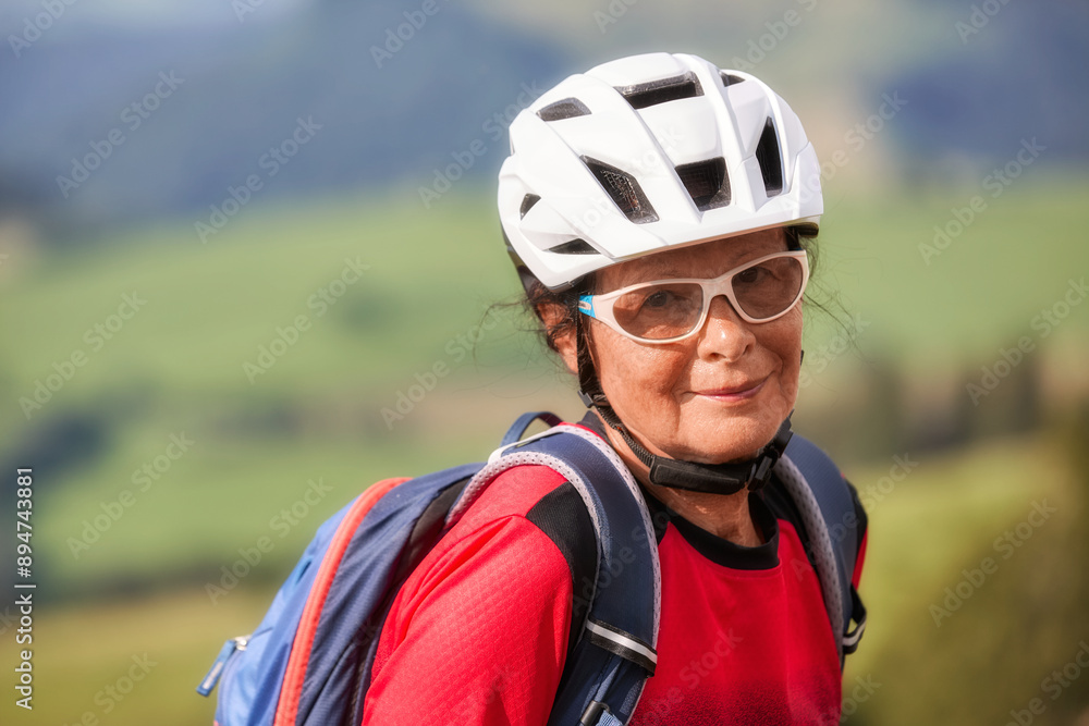 portrait of nice senior woman with cycling helmet backpack and sports outfit portrait of nice senior woman with cycling helmet backpack and sports outfit