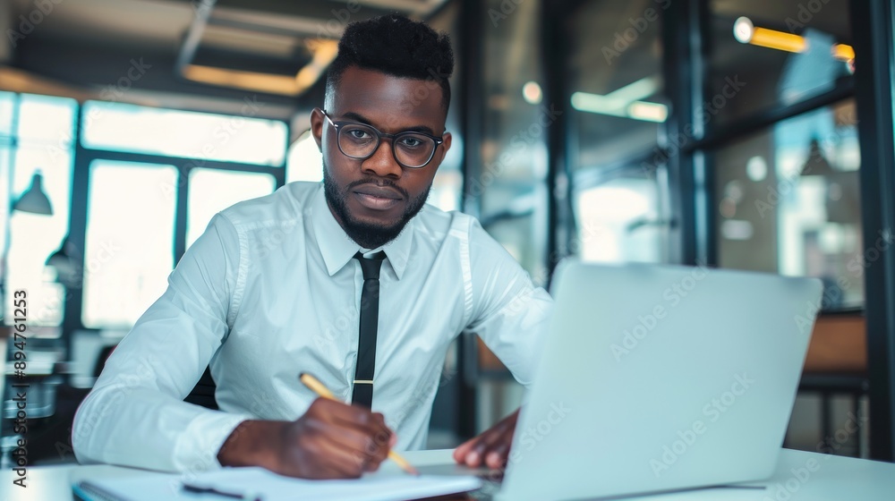 Focused man working on laptop in a modern office. Focused man working on laptop in a modern office.