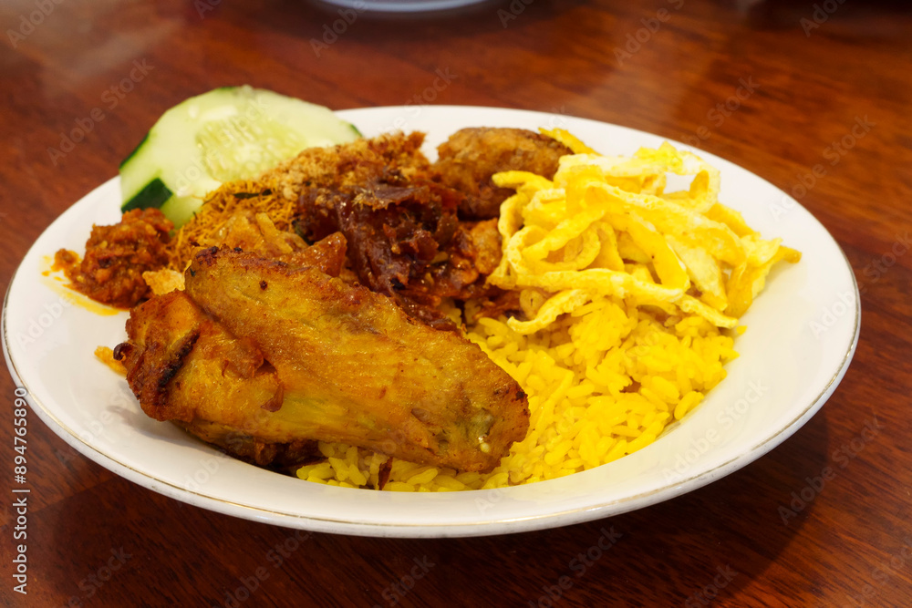 A plate of Nasi Kuning, a traditional Indonesian yellow rice dish. A plate of Nasi Kuning, a traditional Indonesian yellow rice dish.