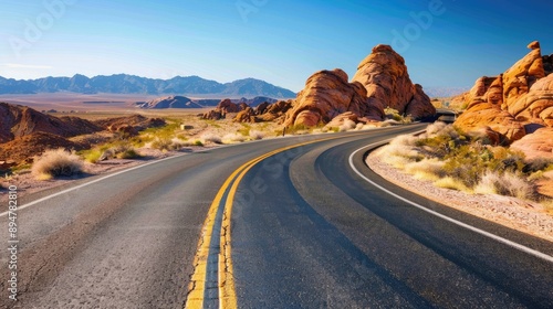 A winding desert road stretching into the horizon under a clear blue sky, symbolizing adventure and exploration.