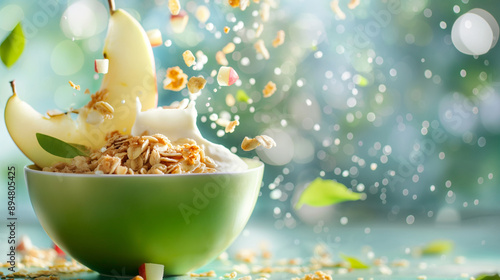 Dynamic splash of pear and apple fruits into the green bowl filled with oatmeal yogurt milk. Healthy vegan mixed meal, nutritious cornflakes breakfast, fiber and energy diet, grano