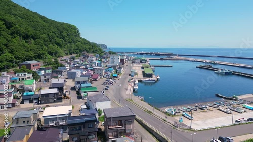 Rausu, Hokkaido: Aerial drone footage of the Rausu town and harbor in the Shiretoko peninsula in Hokkaido in summer in Japan. Shot with an upward and tilt down motion photo