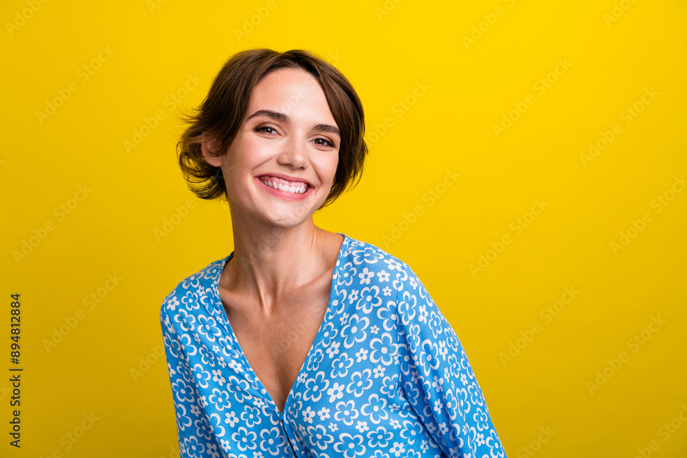 Portrait of toothy beaming gorgeous cute girl with short hairstyle wear blue blouse smiling to you isolated on yellow color background Portrait of toothy beaming gorgeous cute girl with short hairstyle wear blue blouse smiling to you isolated on yellow color background