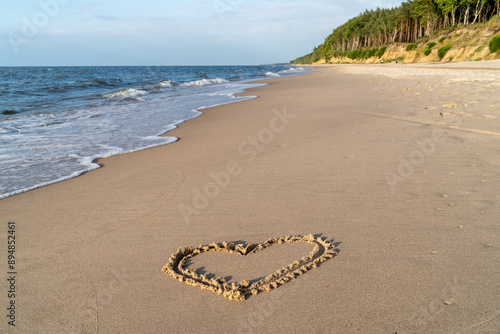 Fototapeta Naklejka Na Ścianę i Meble -  Heart drawn in the sand on the beach at Dziwnowek beach. Heart shape. Heart symbol. Baltic sea, Dziwnówek, Poland, Europe. 