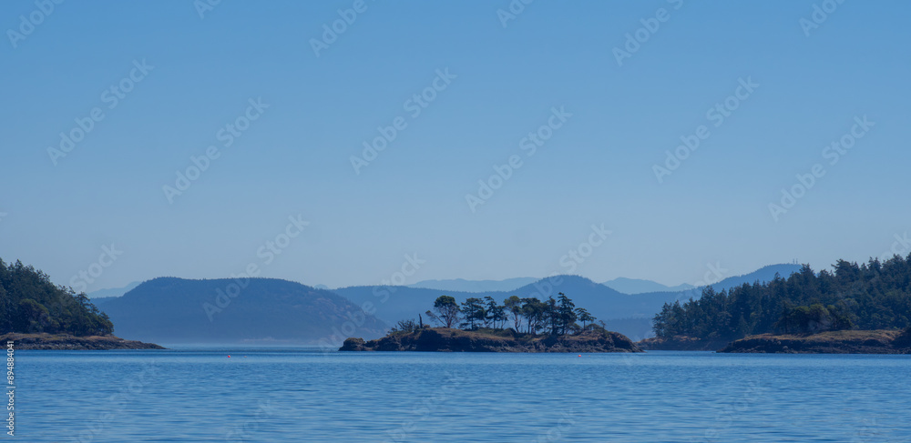 Beautiful views of blue skies, blue seas and nearby islands with trees while cruising the San Juan Islands in Washington State. Beautiful views of blue skies, blue seas and nearby islands with trees while cruising the San Juan Islands in Washington State.