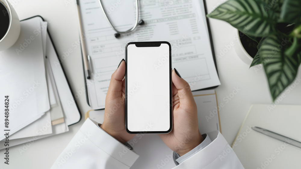 Doctor holding a smartphone with a blank screen at a desk with medical documents. Concept of digital healthcare, mobile technology, and professional medical services Doctor holding a smartphone with a blank screen at a desk with medical documents. Concept of digital healthcare, mobile technology, and professional medical services
