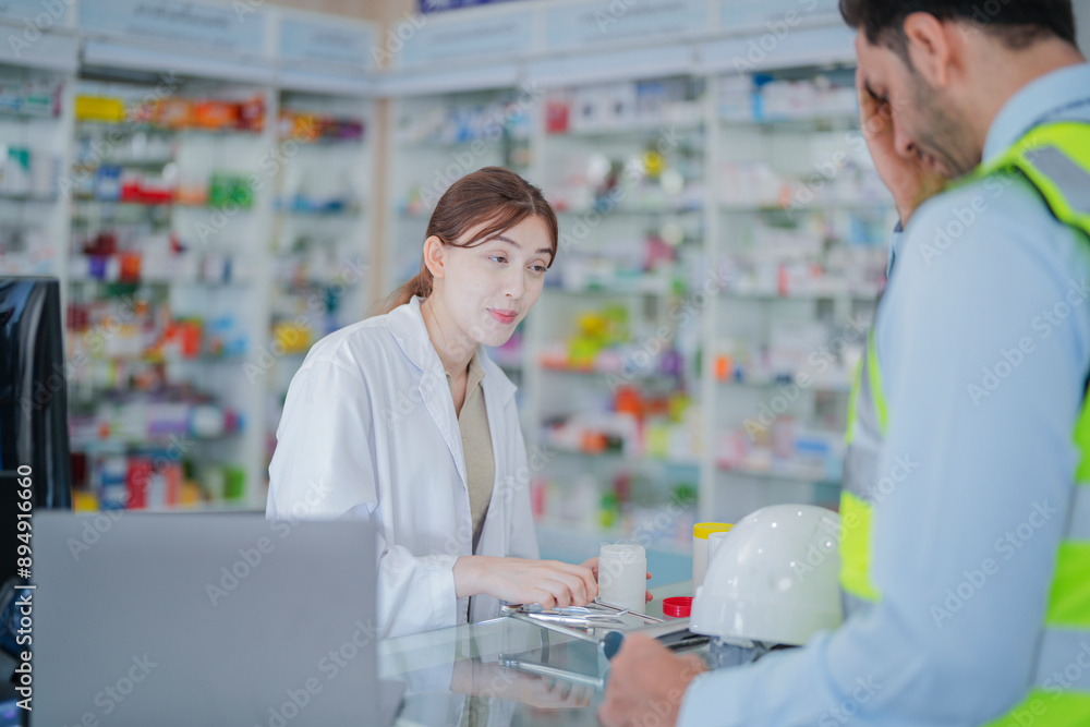 A female pharmacist is talking with a construction worker who needs medicine for pain and discomfort. Pharmacist in a pharmacy with medicines on shelves A female pharmacist is talking with a construction worker who needs medicine for pain and discomfort. Pharmacist in a pharmacy with medicines on shelves