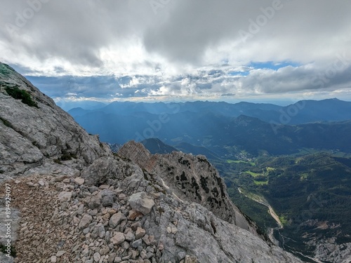 Panoramic view of the Slovenian Alps from a hiking trip and via ferrata to the top of Grintovec mountain on a hot summer day. Stunning alpine landscapes and challenging trails.