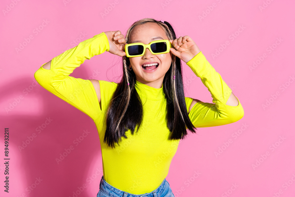 Photo of pretty positive girl with dyed hairstyle dressed yellow shirt touching sunglass smiling isolated on pink color background Photo of pretty positive girl with dyed hairstyle dressed yellow shirt touching sunglass smiling isolated on pink color background