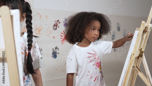 Foto Happy creative african girl painted or draw canvas together with asian boy