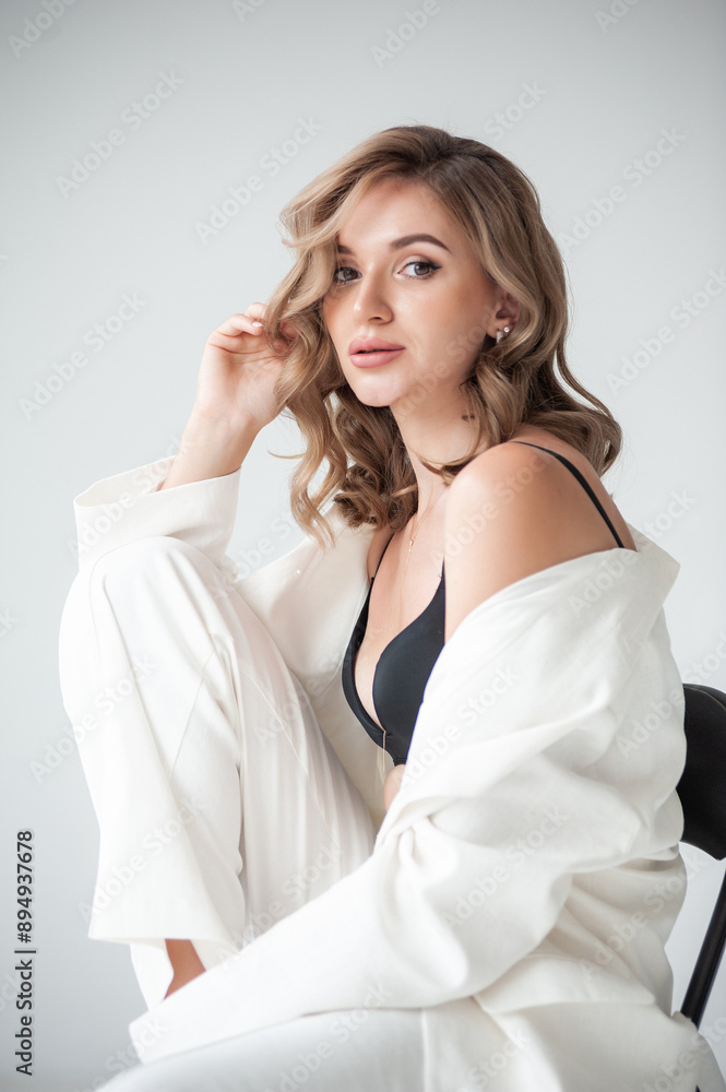 young blonde woman in white jacket and bra on grey background young blonde woman in white jacket and bra on grey background