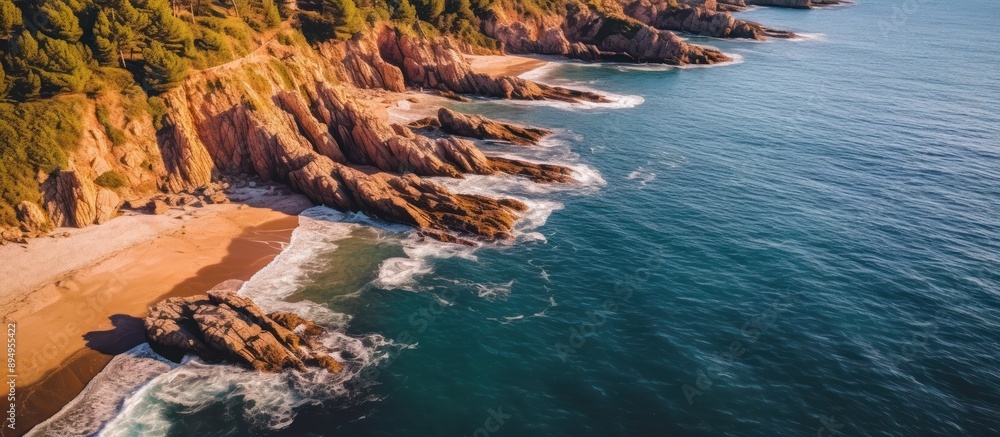 Obraz premium Aerial View of a Rugged Coastline with Foamy Waves