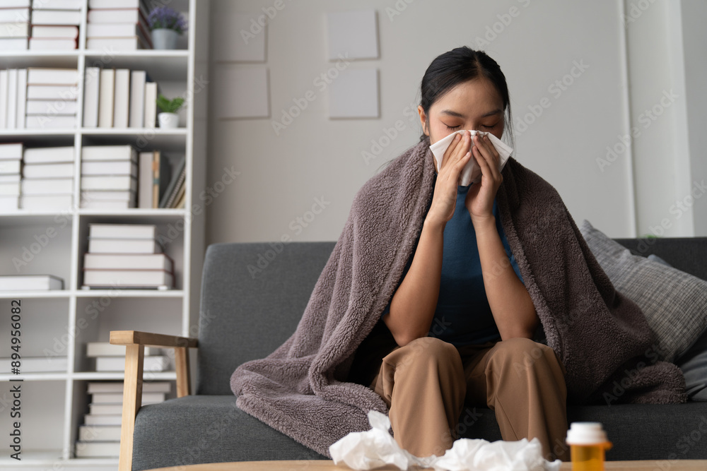 A photograph depicting a female individual in a state of discomfort seated upon a sofa within a residential setting. A photograph depicting a female individual in a state of discomfort seated upon a sofa within a residential setting.