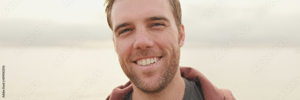 Close-up of young man standing on the shore and looking at camera Close-up of young man standing on the shore and looking at camera