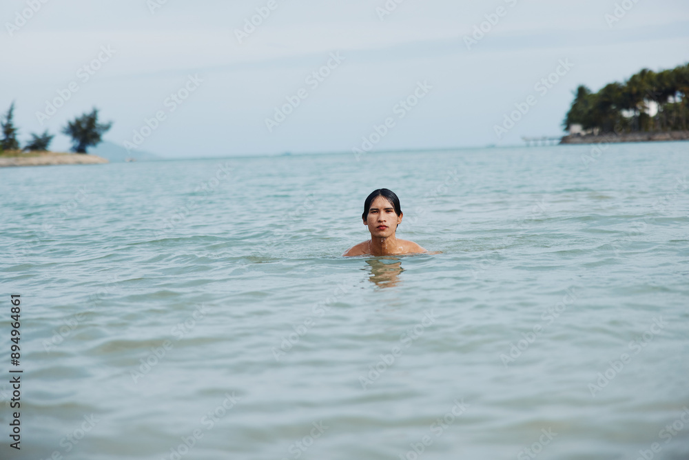 Smiling Asian Man Enjoying a Tropical Vacation: Active Swim and Freedom in the Blue Ocean Smiling Asian Man Enjoying a Tropical Vacation: Active Swim and Freedom in the Blue Ocean