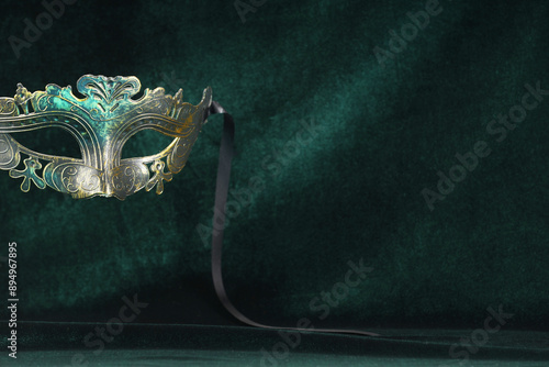 Theater arts. Venetian carnival mask against green fabric, space for text photo