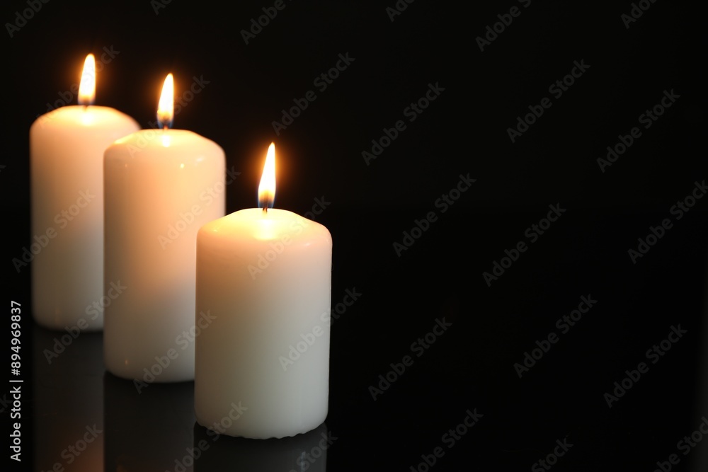 Many burning candles on mirror surface against black background. Space for text Many burning candles on mirror surface against black background. Space for text