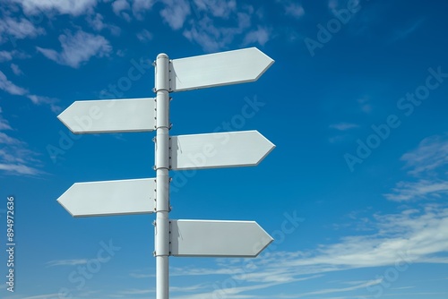 Image of five blank white road signs pointing in different directions against a bright blue sky with scattered clouds.