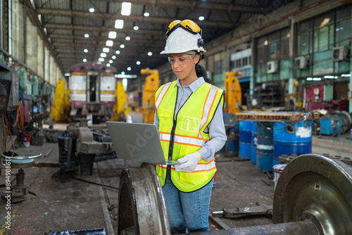 Engineer Analyzing Train Wheelset with Laptop in Depot