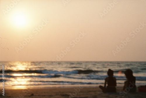 people walking on the beach at sunset