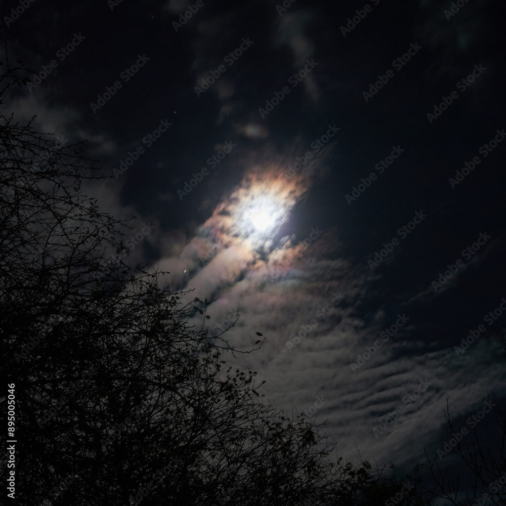 a full moon is seen through the clouds in the sky. a full moon is seen through the clouds in the sky.