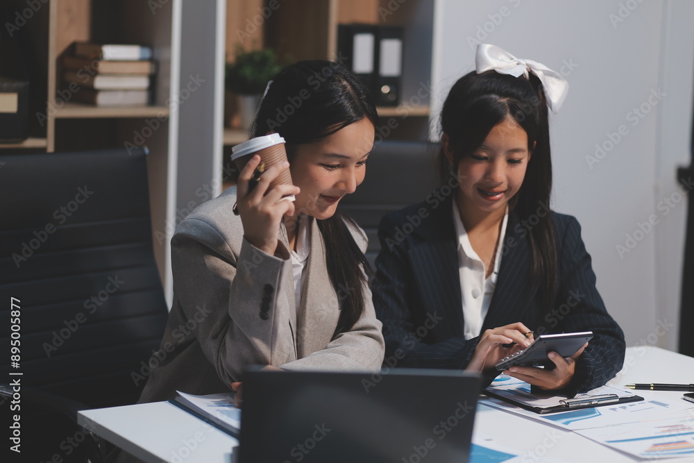 Two young Asian business woman talk, consult, discuss working with new startup project idea presentation analyze plan marketing and investment in the office. Two young Asian business woman talk, consult, discuss working with new startup project idea presentation analyze plan marketing and investment in the office.