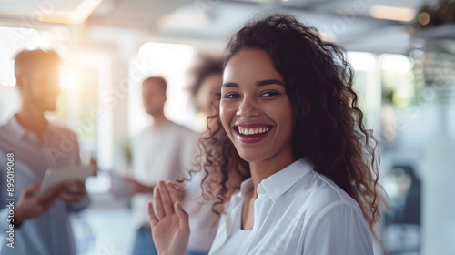 Wallpaper Mural Smiling businesswoman in a modern office with blurred colleagues in the background. Team collaboration, networking, professional environment, workplace diversity, corporate culture. Torontodigital.ca