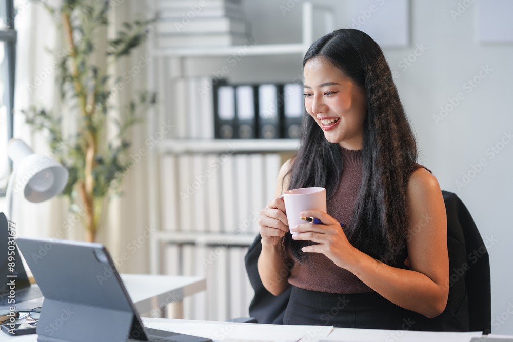 Smiling asian businesswoman enjoys coffee while working from her cozy home office, exuding a cheerful and relaxed vibe Smiling asian businesswoman enjoys coffee while working from her cozy home office, exuding a cheerful and relaxed vibe