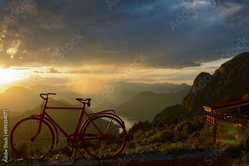 Foto bicycle with sunset, mountains, bay and rain background