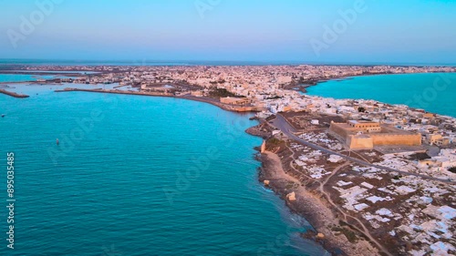 Wallpaper Mural An aerial view of a city of Mahdia with a large body of water and many buildings. The city is situated on the shores of the water, with boats visible in the harbor.at sunrise. Torontodigital.ca