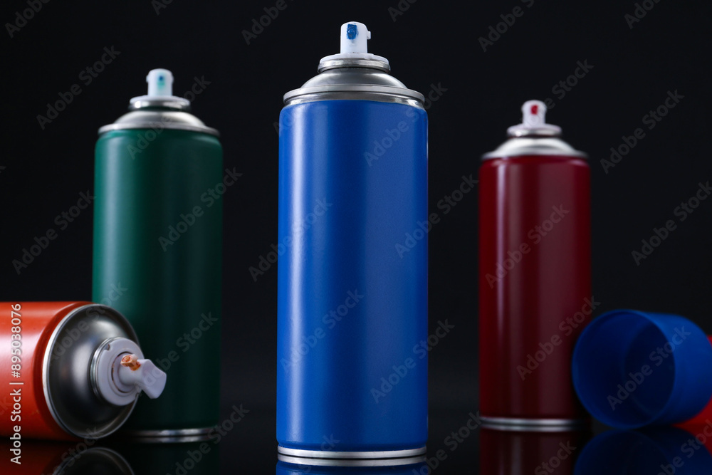Many spray paint cans on black background, closeup Many spray paint cans on black background, closeup
