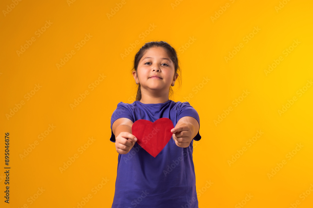 Child girl holding paper heartover yellow background. Love, care and Valentine day concept Child girl holding paper heartover yellow background. Love, care and Valentine day concept