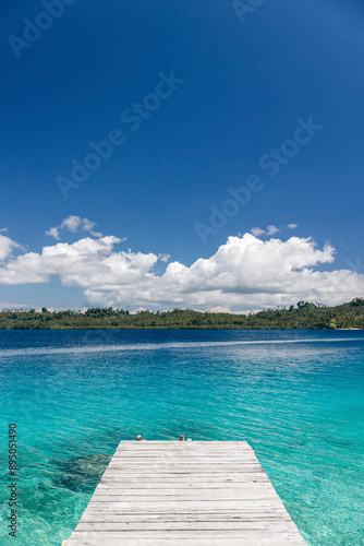 Pier from white sand to clear water on Bolilanga Island in the Togean Islands of Indonesia photo