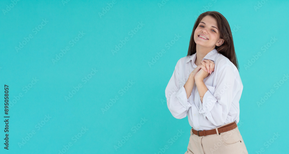 Flattered cute tender feminine young woman press palm chest grateful tilting head smiling. Pleased appreciating nice compliment. Young woman dressed in white shirt stands Flattered cute tender feminine young woman press palm chest grateful tilting head smiling. Pleased appreciating nice compliment. Young woman dressed in white shirt stands