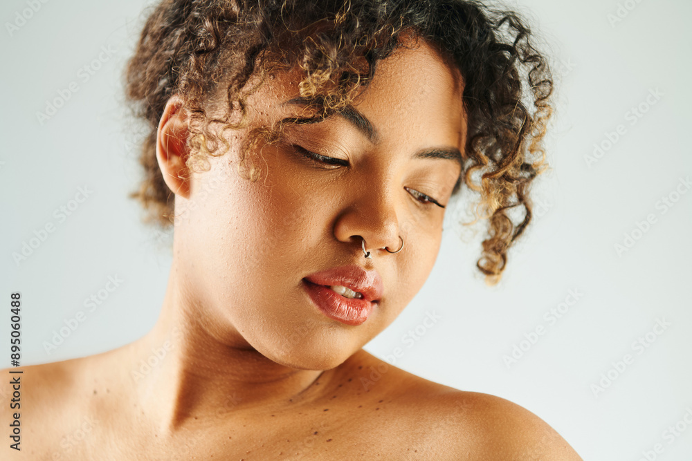 Close-up of an African American woman with curly hair, striking a pose against a vibrant backdrop. Close-up of an African American woman with curly hair, striking a pose against a vibrant backdrop.
