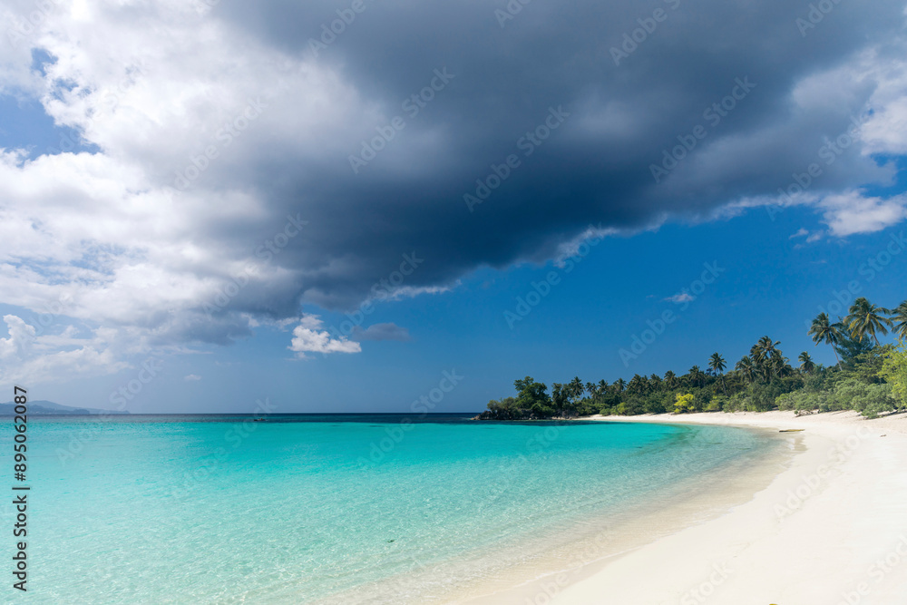 Dramatic cloud formation over the exotic white sand and clear turquoise water of Pantai Oyama in Sulawesi Tengah, Indonesia; Popisi, Banggai Utara, Kabupaten Banggai Laut, Sulawesi Tengah, Indonesia Dramatic cloud formation over the exotic white sand and clear turquoise water of Pantai Oyama in Sulawesi Tengah, Indonesia; Popisi, Banggai Utara, Kabupaten Banggai Laut, Sulawesi Tengah, Indonesia