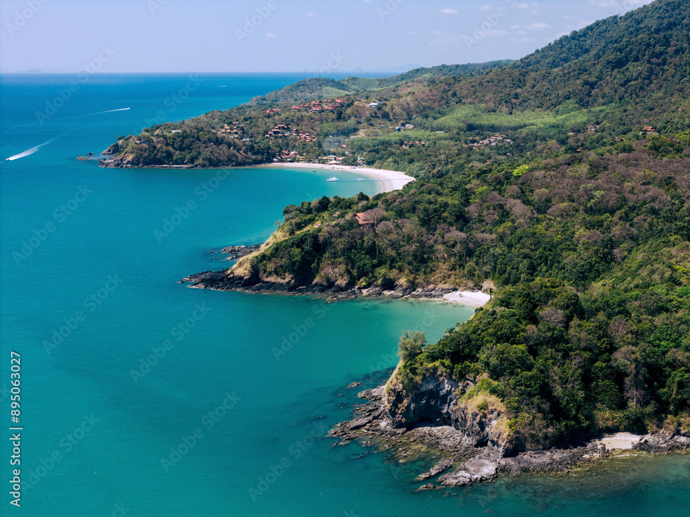Beautiful rugged coastline with trees, white sand beaches and turquoise ocean water at Koh Lanta, Krabi, Thailand; Koh Lanta, Krabi, Thailand Beautiful rugged coastline with trees, white sand beaches and turquoise ocean water at Koh Lanta, Krabi, Thailand; Koh Lanta, Krabi, Thailand