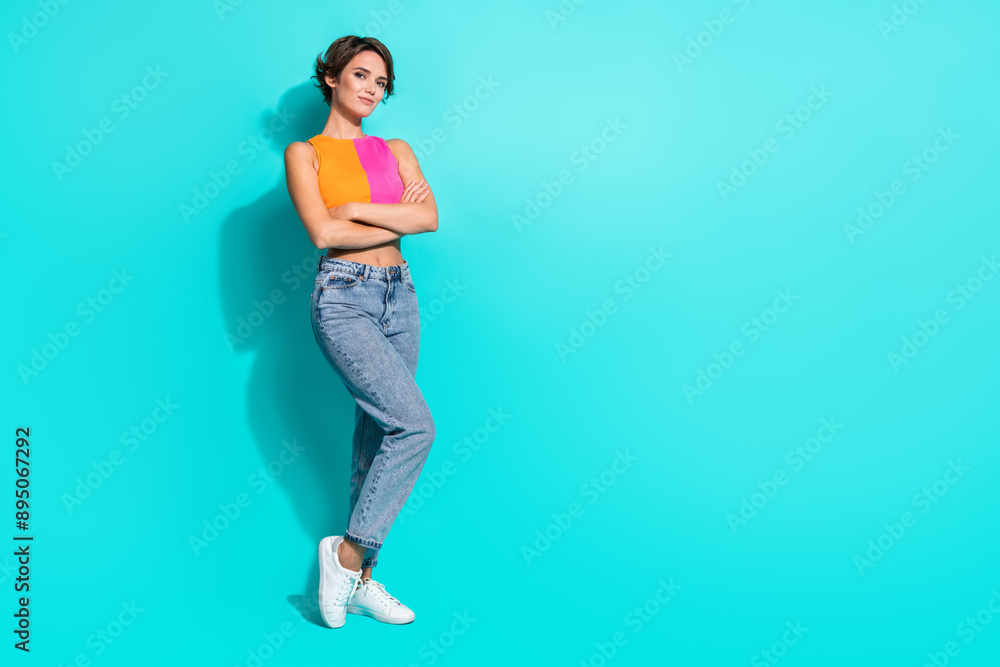 Full length photo of adorable confident woman wear pink orange top arms folded empty space isolated teal color background Full length photo of adorable confident woman wear pink orange top arms folded empty space isolated teal color background