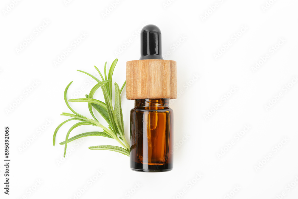 Aromatic essential oil in bottle and rosemary on white background, top view Aromatic essential oil in bottle and rosemary on white background, top view