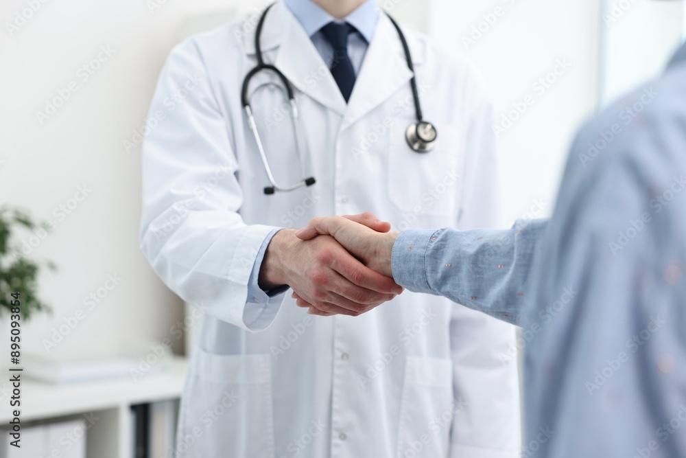 Doctor shaking hands with patient in clinic, closeup Doctor shaking hands with patient in clinic, closeup