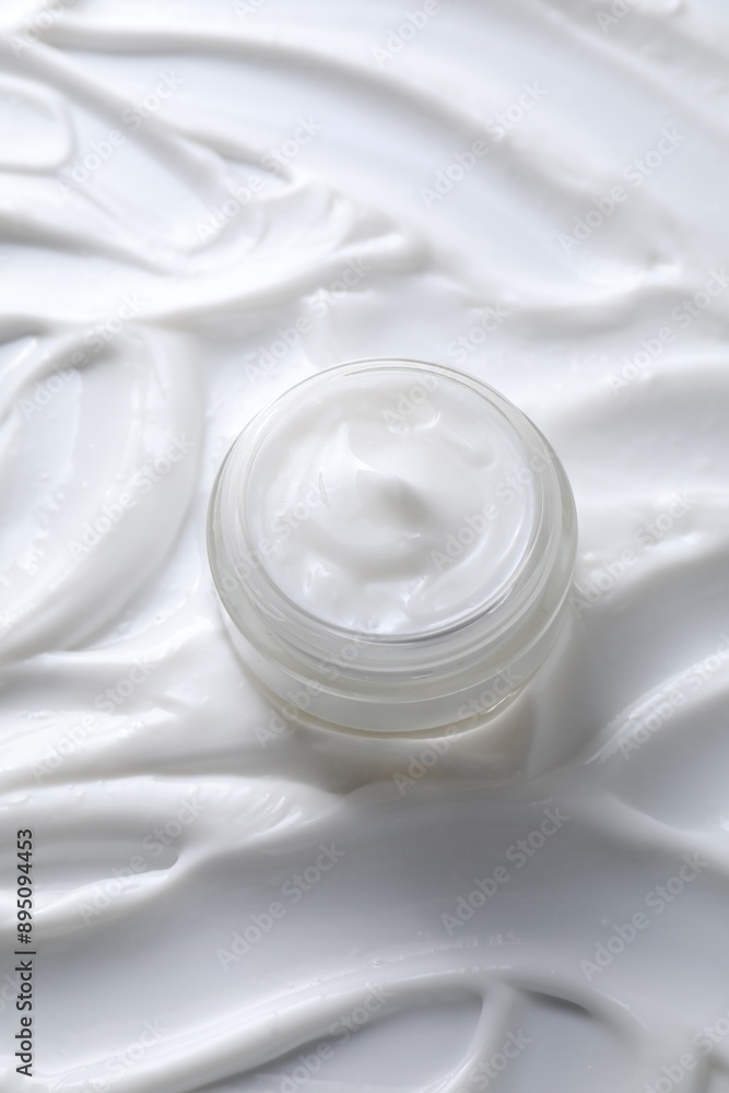 Face cream in jar on cosmetic product, above view Face cream in jar on cosmetic product, above view