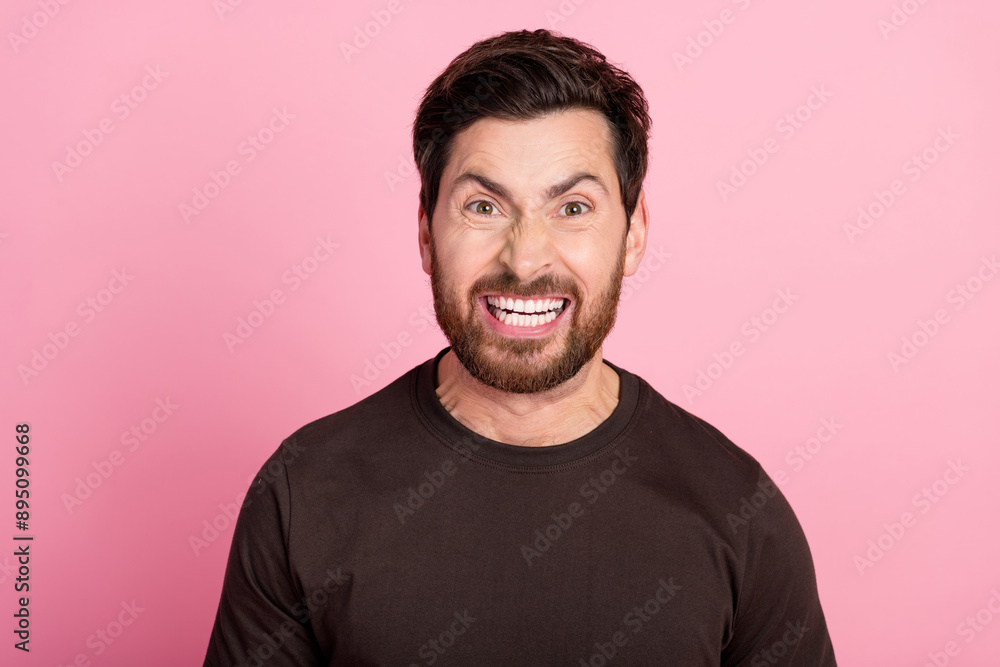Obraz premium Photo of gloomy aggressive mad guy with stubble brunet hair dressed brown t-shirt screaming show teeth isolated on pink color background
