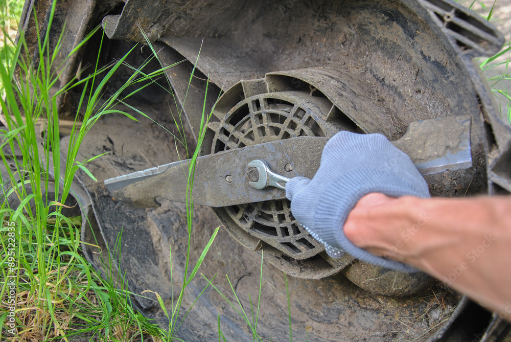 Obraz premium Replacing a lawn mower blade. electric lawn mower repair