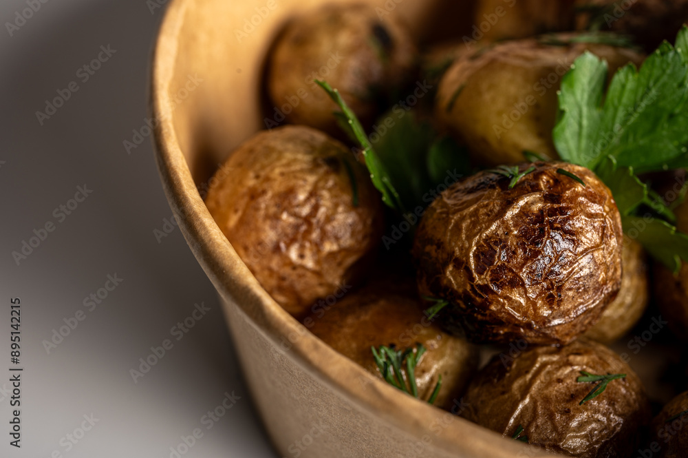 fried new potatoes cooked with golden skin, fast food delivery in kraft paper packaging on light background, place for inscription fried new potatoes cooked with golden skin, fast food delivery in kraft paper packaging on light background, place for inscription